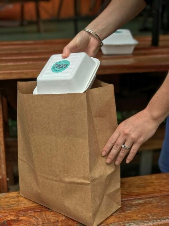 A takeaway order being packed into a paper bag