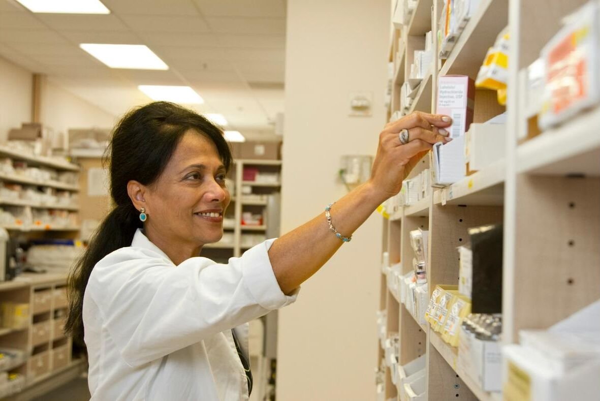 A pharmacist choosing a medicine box from the shelf
