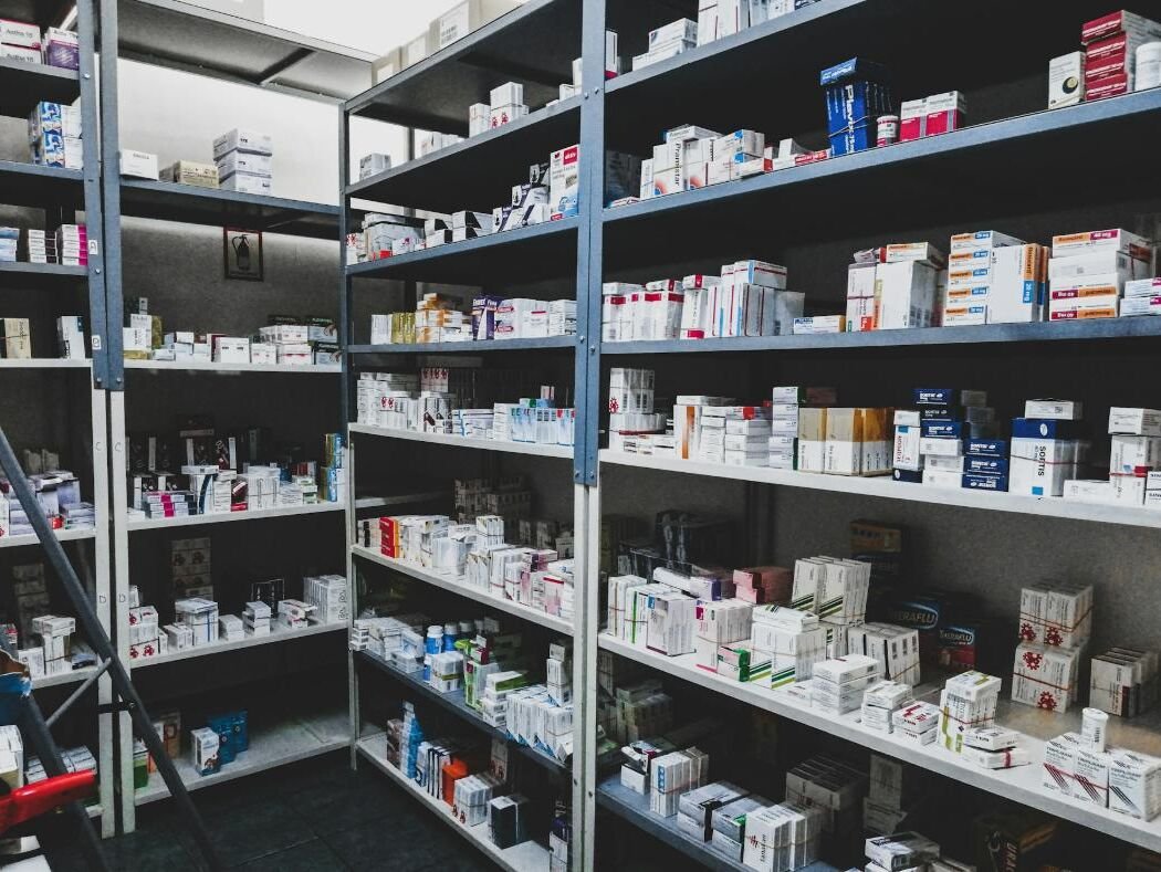Pharmacy shelves stocked with medicine boxes