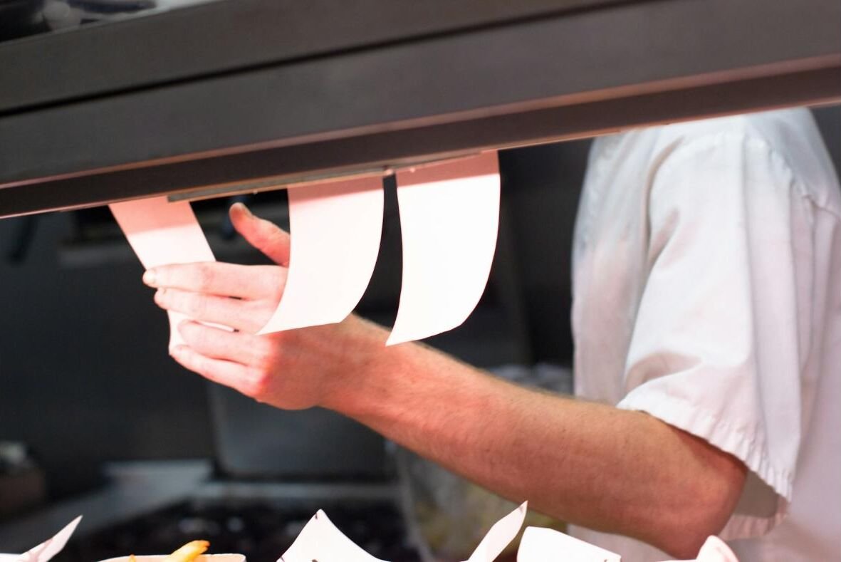 Order tickets lined up on a rail during a busy service